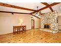 Inviting living room boasts wood floors, exposed beams, stone fireplace, and a ceiling fan for added comfort at 353 Wekiva Cove Rd, Longwood, FL 32779