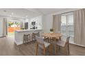 Bright dining area featuring a modern table set, luxury vinyl plank floors, and an adjacent kitchen at 3622 Huntwicke Blvd, Davenport, FL 33837