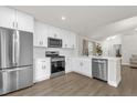 Bright kitchen with stainless steel appliances, white cabinets, and luxury vinyl plank flooring at 3622 Huntwicke Blvd, Davenport, FL 33837