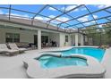 Relaxing screened pool area with lounge chairs, outdoor dining, and a built-in spa at 418 Gleaming Andover Way, Longwood, FL 32779