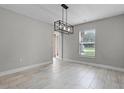Open dining room features modern light fixture, window, and tiled floors at 4519 Willamette Cir, Orlando, FL 32826