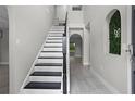 Bright foyer showcases the staircase with wooden banister and decorative greenery detail with tiled floors at 4519 Willamette Cir, Orlando, FL 32826
