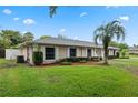 Side view of the property showcasing the manicured lawn and beautiful landscaping with mature trees at 5089 Jennifer Pl, Orlando, FL 32807