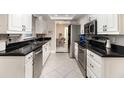 Modern kitchen featuring white cabinets, black countertops, and stainless steel appliances at 7058 Archwood Dr, Orlando, FL 32819