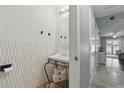 Cozy half bathroom featuring a unique vanity, decorative mirror, and white accent wall at 720 Celebration Ave # 245, Kissimmee, FL 34747
