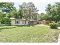 A charming one-story home with a neatly kept lawn and a welcoming entrance at 881 Cedar Cir, Tavares, FL 32778