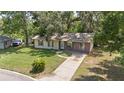 Inviting one-story home with a spacious front lawn and a paved driveway at 881 Cedar Cir, Tavares, FL 32778