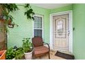 Cozy front porch with plants, chair, and a secure front door with storm door to greet visitors at 1028 Ocala Woods Ln, Orlando, FL 32824