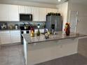 Bright kitchen features an island with a sink, stainless steel appliances, and plenty of cabinet space at 12035 Holystone St, Winter Garden, FL 34787