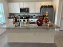 Bright kitchen features an island with a sink, stainless steel appliances, and plenty of cabinet space at 12035 Holystone St, Winter Garden, FL 34787