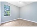 Bright bedroom featuring clean laminated floors, neutral paint, a ceiling fan, and natural light at 13018 S Sunset Ter, Winter Garden, FL 34787
