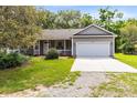 Charming gray home with a two car garage, covered porch, and well maintained front yard at 13018 S Sunset Ter, Winter Garden, FL 34787