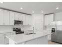 Modern kitchen with stainless steel appliances, white cabinetry, and a center island with a sink at 1345 Griffon Ave, Lake Alfred, FL 33850