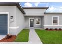 Inviting home entrance with a well-lit porch, lush green lawn, and a neatly paved walkway at 14915 Sw 39Th Cir, Ocala, FL 34473