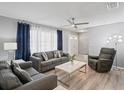 Bright living room with modern furniture, a ceiling fan, and natural light filtering through large windows at 1514 Sparrow St, Longwood, FL 32750