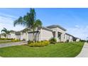 Inviting single-story home with a well-maintained lawn, paved driveway, and tropical palm trees at 1650 Key Bay Trl, Kissimmee, FL 34747