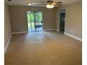 Inviting living room with tile floors, ceiling fan, neutral walls, and sliding glass doors leading to outdoor space at 2085 San Jose Blvd, Orlando, FL 32808