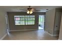 Spacious living room featuring tile floors, a ceiling fan, neutral wall color, and a view of the yard at 2085 San Jose Blvd, Orlando, FL 32808