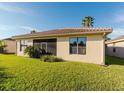 View of the backyard featuring lush grass and the exterior of the home at 223 Monterey St, Kissimmee, FL 34759