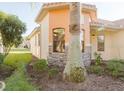 Close-up exterior of a home with stone accents, an arched window, a tile roof and landscaping at 223 Monterey St, Kissimmee, FL 34759