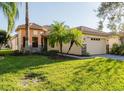 Attractive home with a well-maintained lawn, palm trees, a tile roof and a two-car garage at 223 Monterey St, Kissimmee, FL 34759