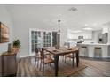 Dining area with wooden table and chairs, seamlessly connecting to the modern, all-white kitchen at 229 Marcum Trace Dr, Lakeland, FL 33809