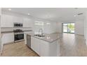 Bright, modern kitchen with stainless steel appliances, central island, and white cabinetry at 2292 Sirena Ln, Mount Dora, FL 32757