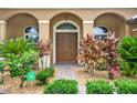 Inviting front entrance showcasing a double door entry surrounded by lush landscaping at 2313 Pesaro Cir, Ocoee, FL 34761