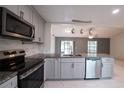 Modern kitchen with stainless steel appliances, granite countertops, and stylish pendant lighting at 3149 Quail Dr, Deltona, FL 32738