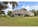 Charming front of the home with lush landscaping and covered porch, set on a spacious lot under a beautiful sky at 3201 Oaklea Dr, Deland, FL 32720