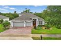 Aerial view of attractive single-story home with brick driveway and manicured lawn with mature trees at 405 Courtlea Park Dr, Winter Garden, FL 34787