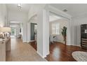 Inviting hallway featuring tiled and wood flooring, architectural columns, and plenty of natural light at 405 Courtlea Park Dr, Winter Garden, FL 34787
