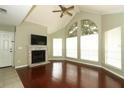 Bright living room featuring wood floors, a fireplace, vaulted ceilings, and large windows at 620 Glenwood Ct # 79, Altamonte Springs, FL 32714