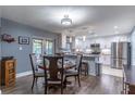 Open kitchen and dining area featuring stainless steel appliances, white cabinets, and modern light fixtures at 638 Boniview Ln, Altamonte Springs, FL 32714