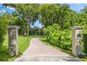 Long winding brick driveway leads to a private estate surrounded by lush greenery and mature trees at 685 Mayo Ave, Maitland, FL 32751