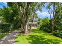 Expansive lawn and brick driveway with mature trees lead to this beautiful home at 685 Mayo Ave, Maitland, FL 32751