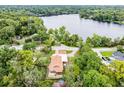 Breathtaking aerial view of a lakeside home surrounded by lush greenery and mature trees at 740 Florida Blvd, Altamonte Springs, FL 32701
