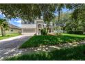 Inviting two-story home with a lush green lawn, mature landscaping, and a brick driveway at 809 Kazaros Cir, Ocoee, FL 34761