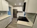 Well-lit kitchen with stainless steel appliances, subway tile backsplash and white cabinetry at 8320 Dominguin St, Orlando, FL 32817