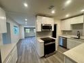 Open concept kitchen and living space featuring stainless appliances and modern finishes at 8320 Dominguin St, Orlando, FL 32817