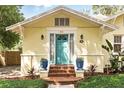 Inviting front entrance with a bright blue door, brick steps, and decorative potted plants on each side at 835 Antonette Ave, Winter Park, FL 32789