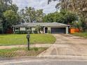 Beautifully maintained single-story house with a well-kept lawn, a driveway, and an attached two-car garage at 8404 Singapore Ct, Orlando, FL 32817