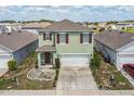 Aerial view of two-story home with two-car garage, landscaped yard, and neighborhood at 129 Eagleview Loop, Davenport, FL 33837
