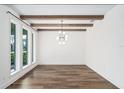 Bright living room featuring wood flooring, exposed wood beams, large windows, and modern light fixture at 1414 W New Hampshire St, Orlando, FL 32804