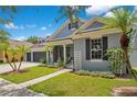 Attractive one-story home with a well-manicured lawn, palm trees, and a three-car garage on a sunny day at 14306 Paradise Tree Dr, Orlando, FL 32828