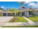 Charming one-story home with landscaped front yard, gray paint, black shutters, and a spacious three-car garage at 14306 Paradise Tree Dr, Orlando, FL 32828