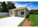 Single-story tan home featuring a modern design, well-kept landscaping, a concrete driveway, and a welcoming front entrance at 144 Mandrake St, Orlando, FL 32811