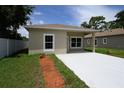 Tan single story home with a modern design, concrete driveway, and a well-maintained, landscaped yard at 144 Mandrake St, Orlando, FL 32811