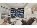 Cozy living room with blue bookcase, stylish chairs, and ample natural light from the window at 15038 Masthead Landing Cir, Winter Garden, FL 34787
