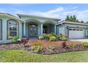 Stunning front exterior featuring a lush landscaped garden, double door entry, and an attached garage at 19232 Somerset St, Orlando, FL 32833